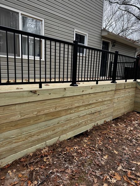 Wooden retaining wall with black railing