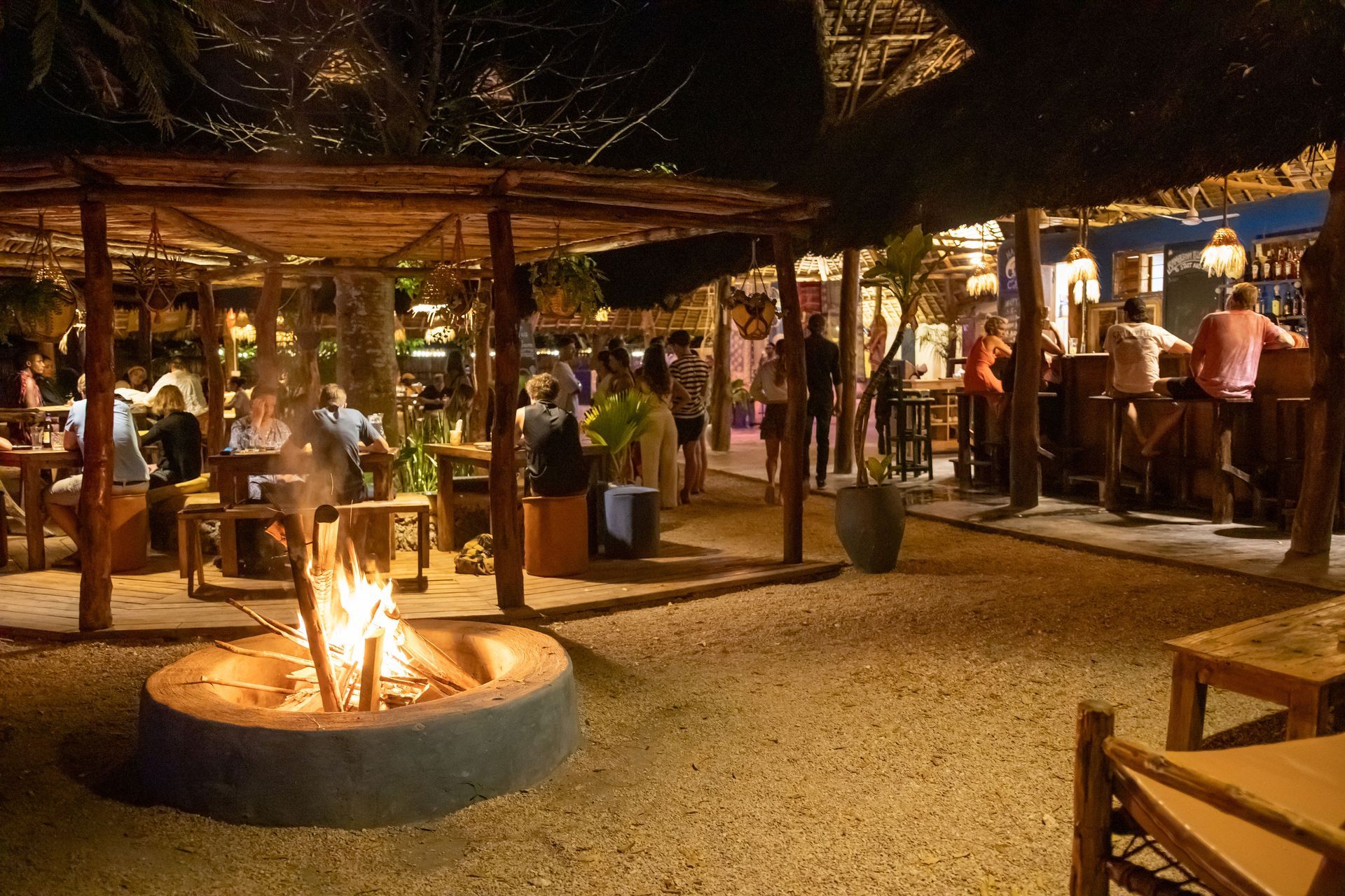 A group of people are sitting at a wooden table in a restaurant.