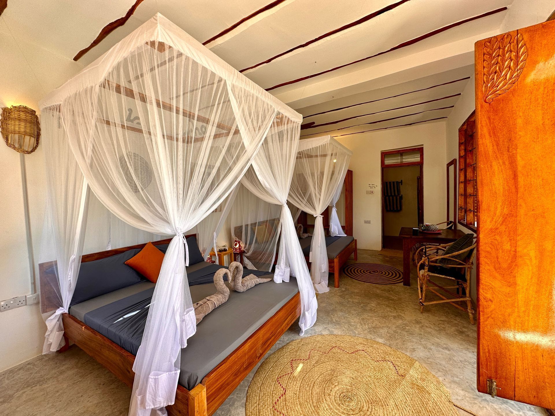 A bedroom with a canopy bed and mosquito nets.