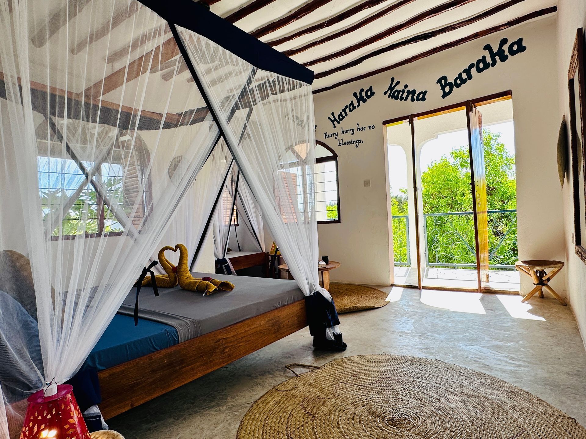 A bedroom with a canopy bed and a sliding glass door.