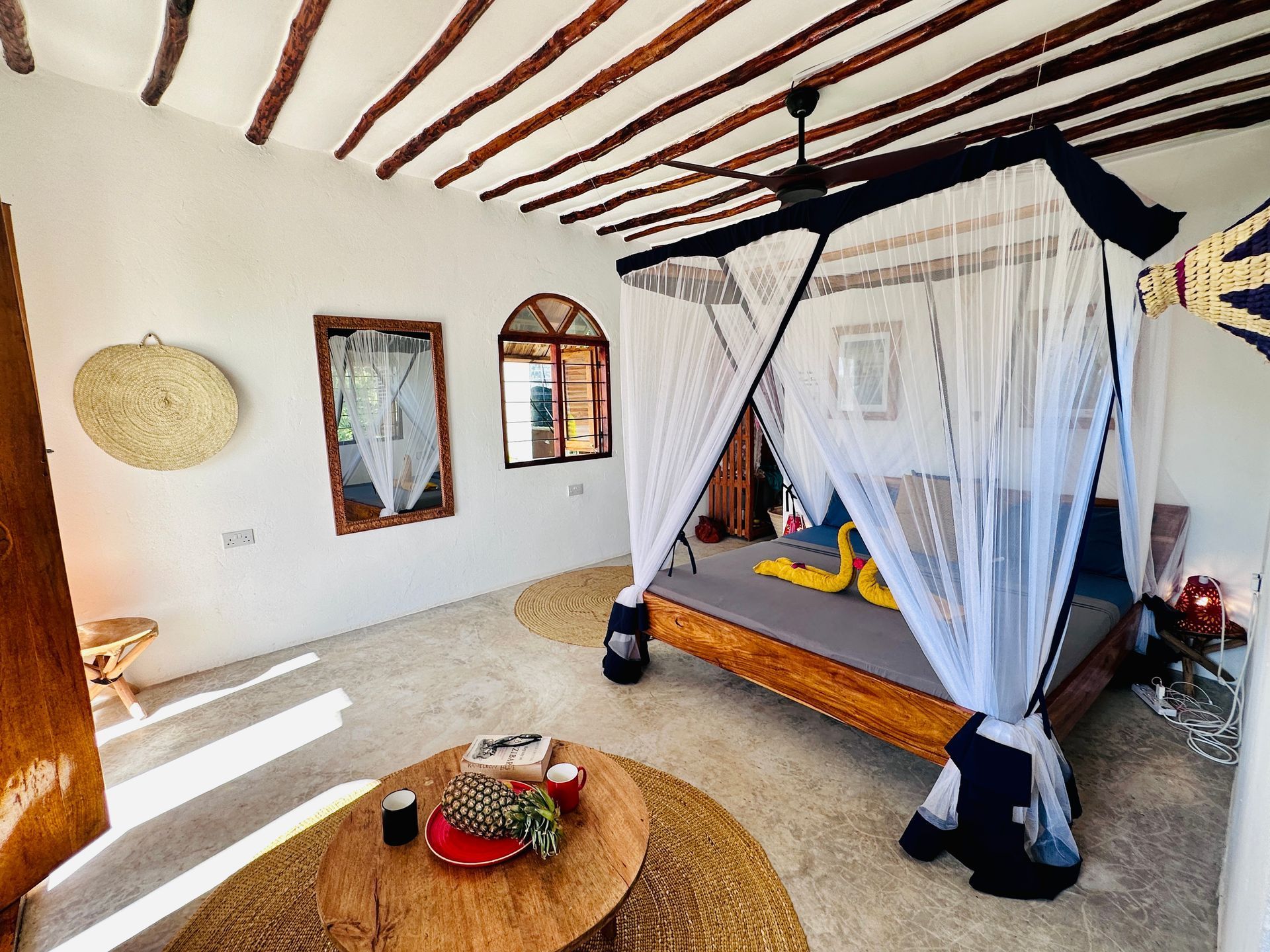 A bedroom with a canopy bed and a wooden table.