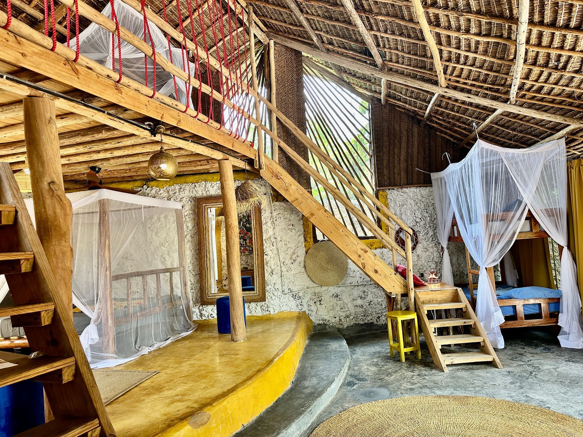 Rustic interior with loft, bunk beds, and natural light.