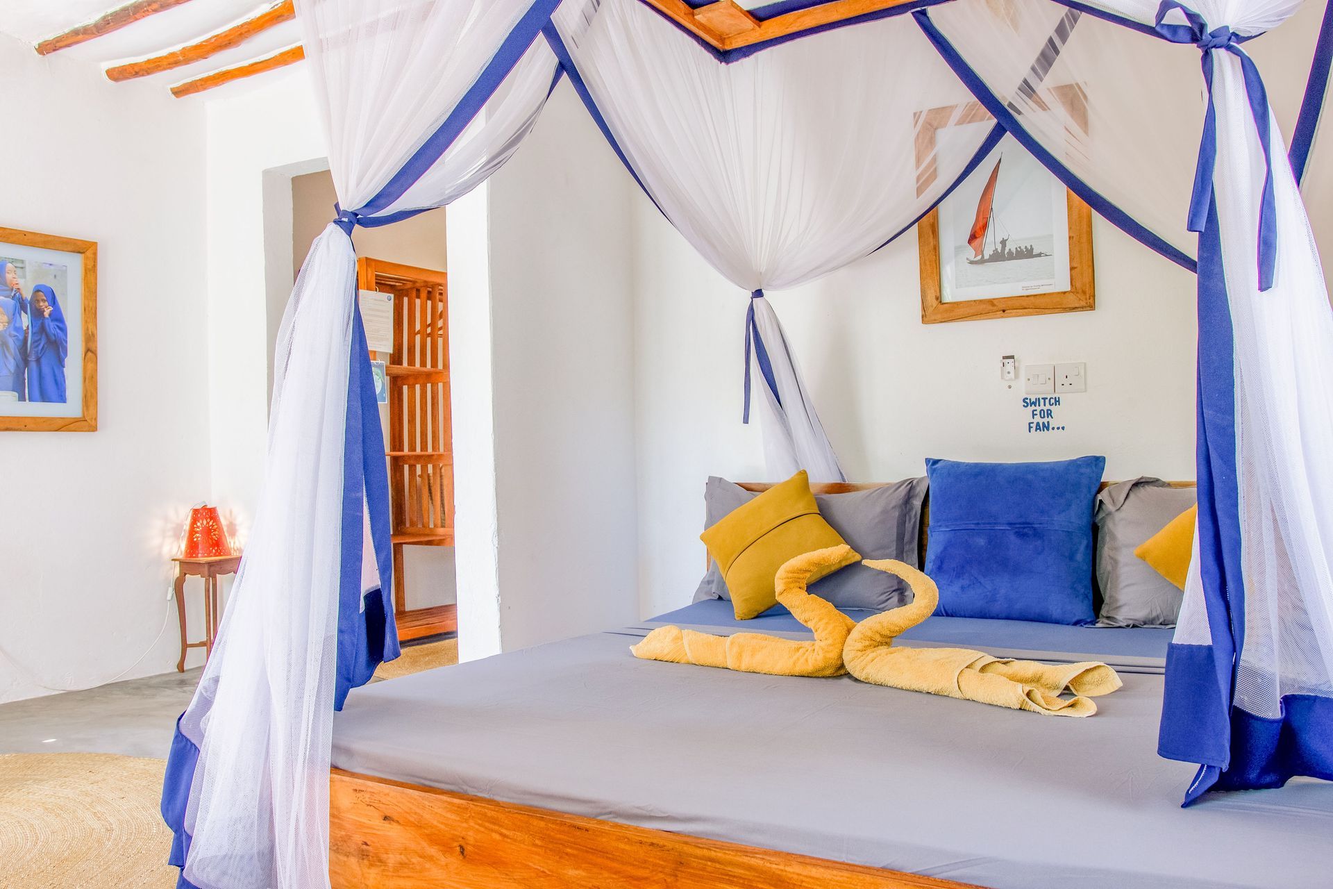 Bedroom with canopy bed, blue and yellow accents.