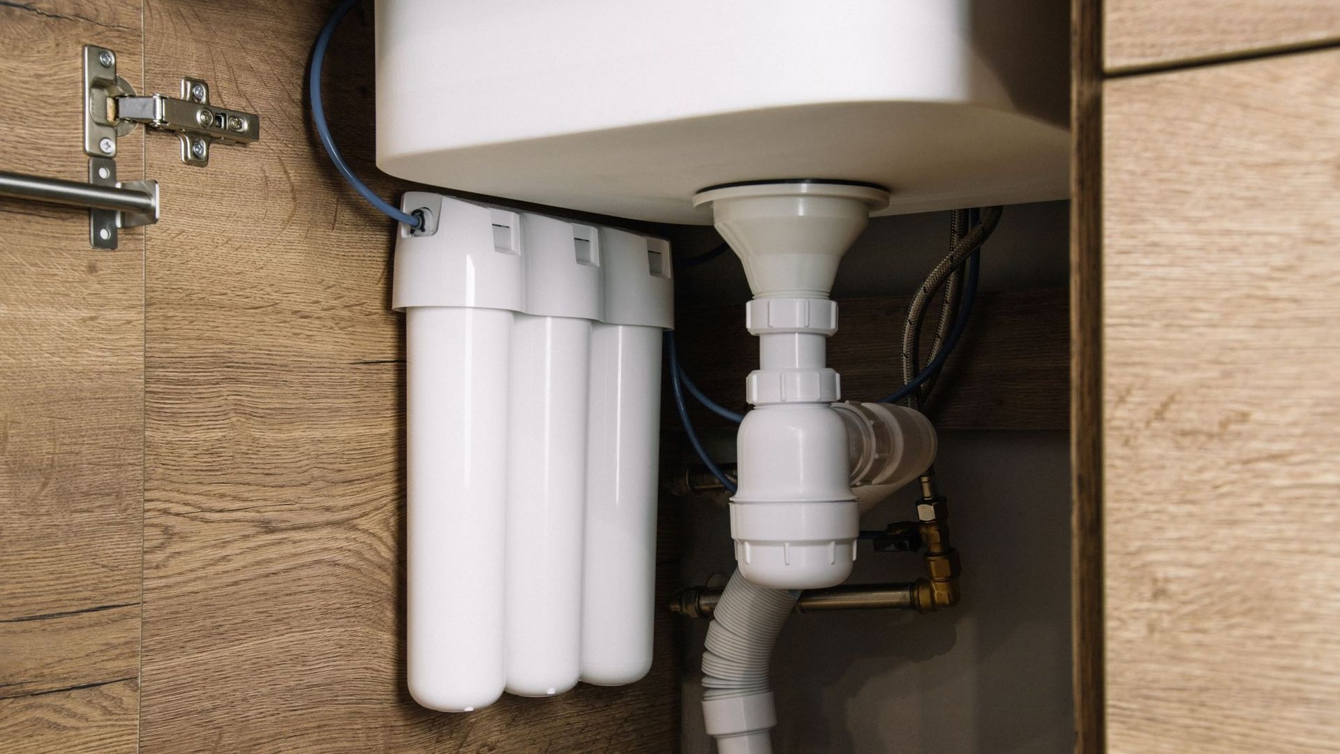 A sink with a water filter underneath it in a kitchen.