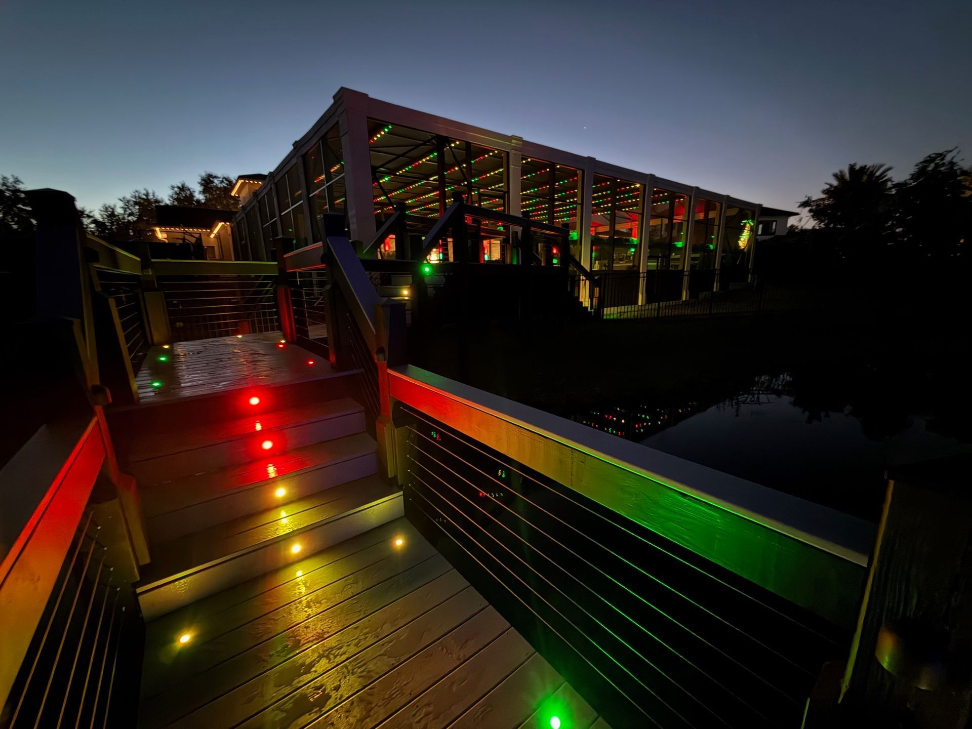 Modern house exterior with carport, driveway, and garage. Green plants and stone accents.