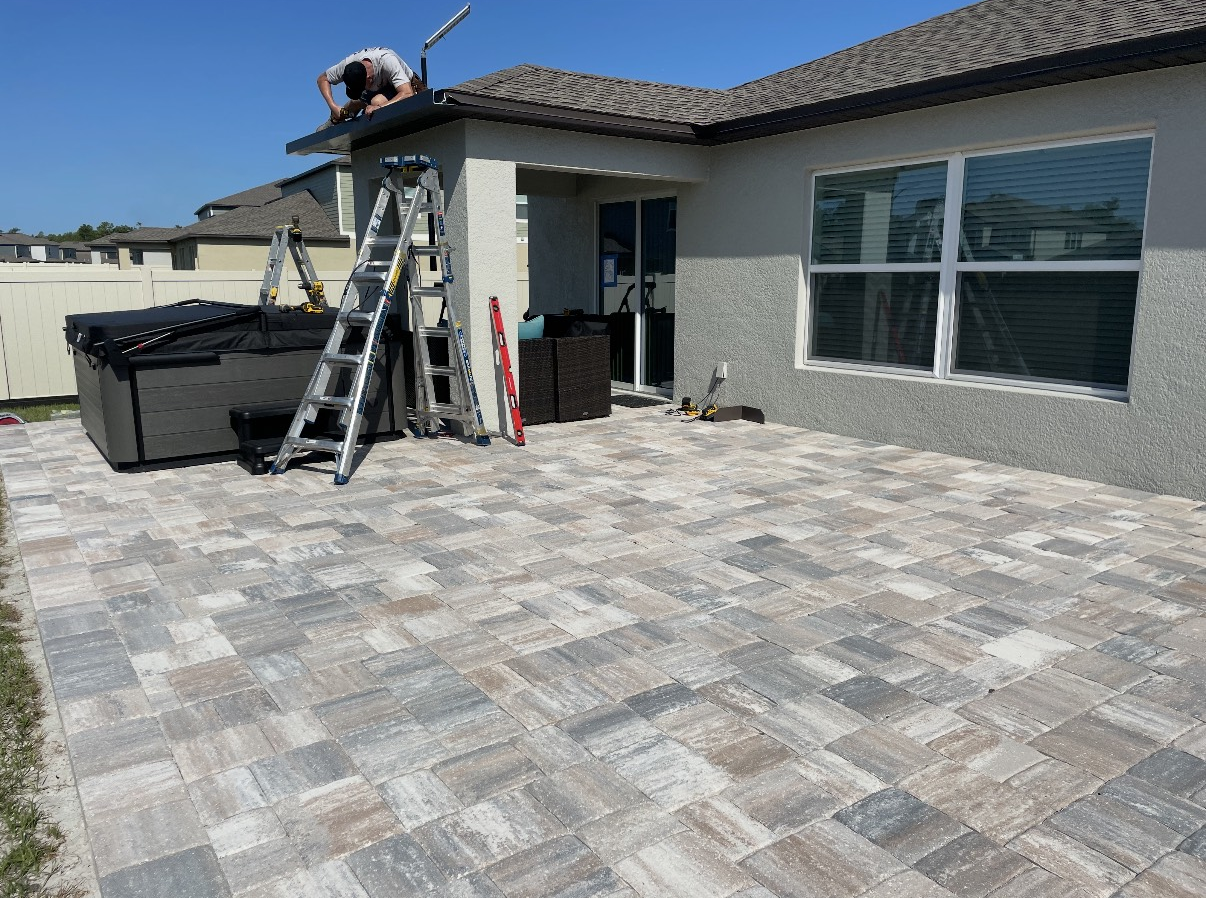 Backyard with pool, patio, and play structure under a sunset sky.