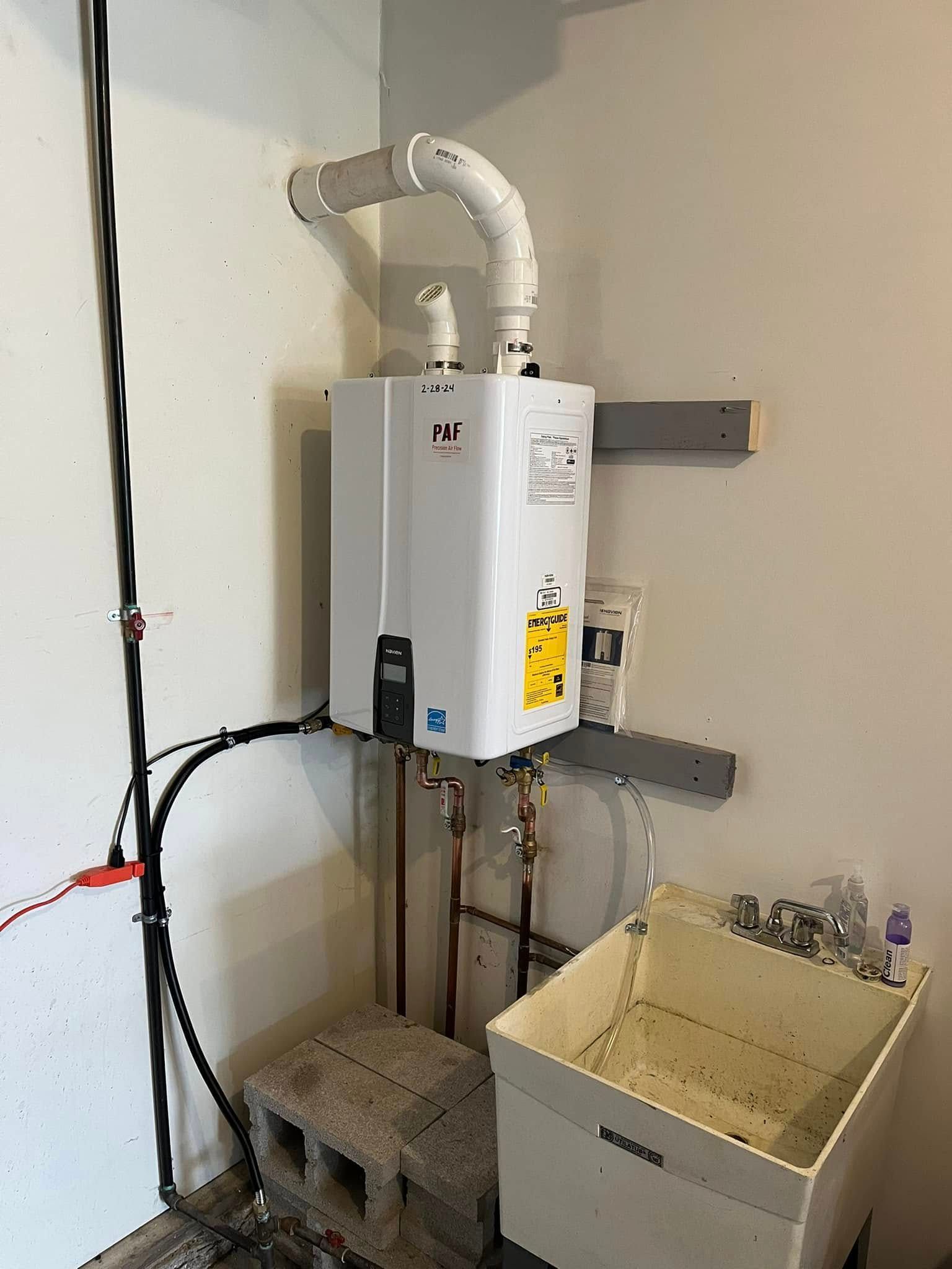 A water heater is mounted to the wall next to a laundry sink.