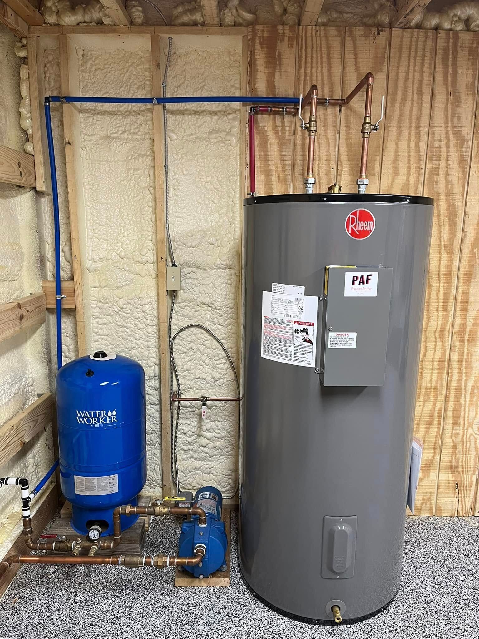 A large gray water heater is sitting in a room next to a blue tank.