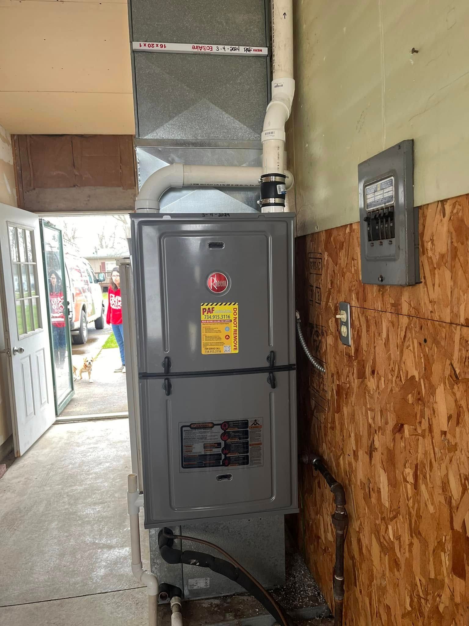 An air conditioner is installed in a hallway next to a wooden wall.