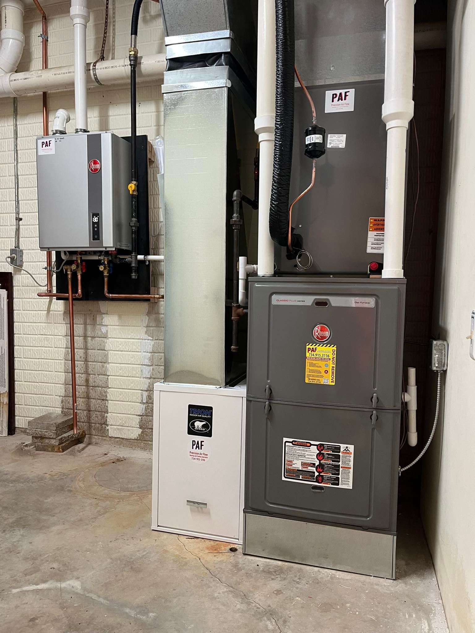 A boiler and a water heater are in a basement.