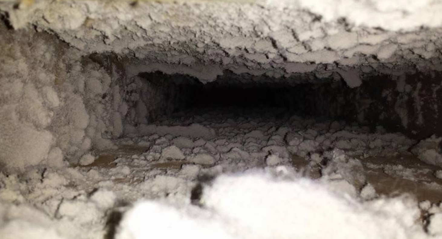 A dirty air vent with a lot of dust coming out of it.