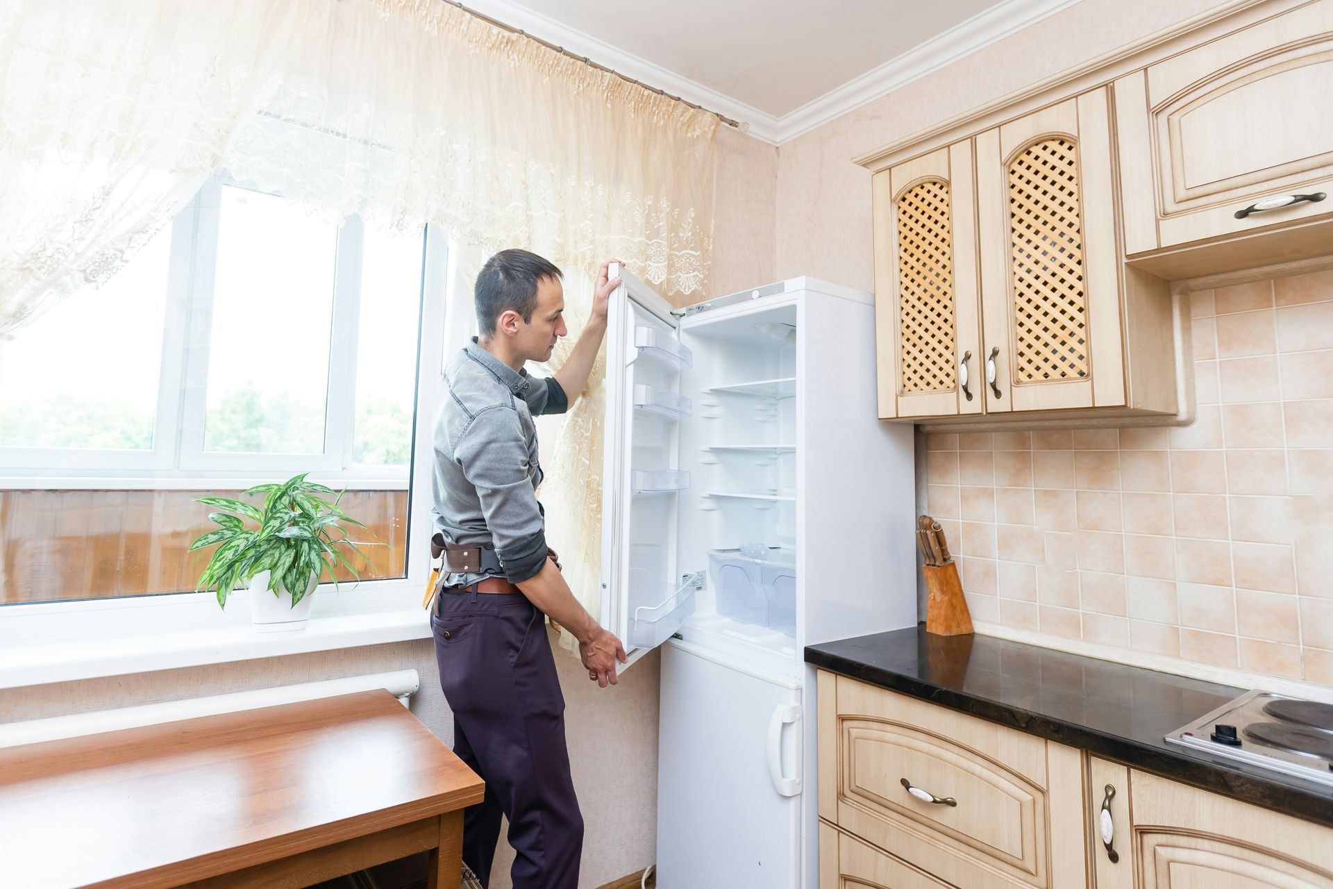 Person organizing an open refrigerator in a bright kitchen
