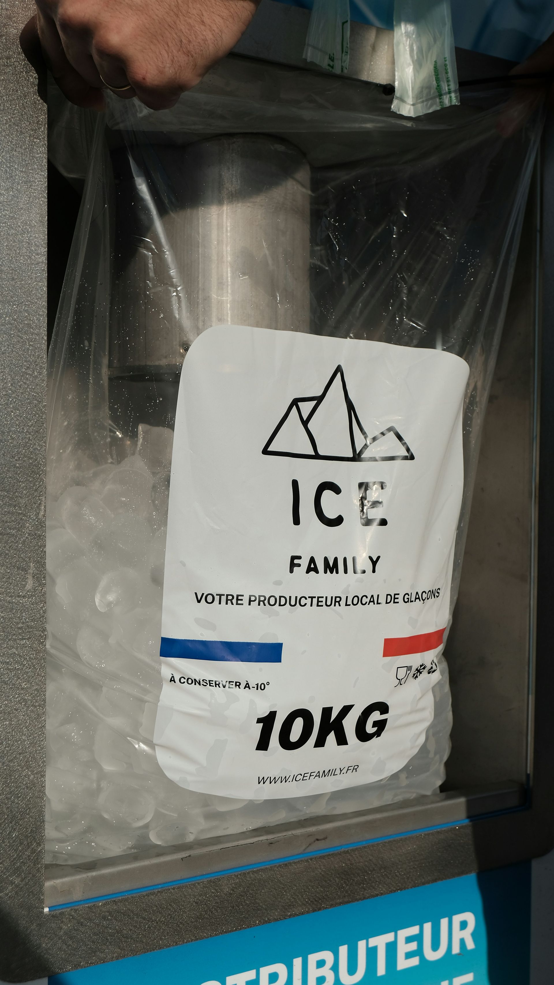 White 10KG ice bag in a freezer dispenser, with blue and red accents on the machine