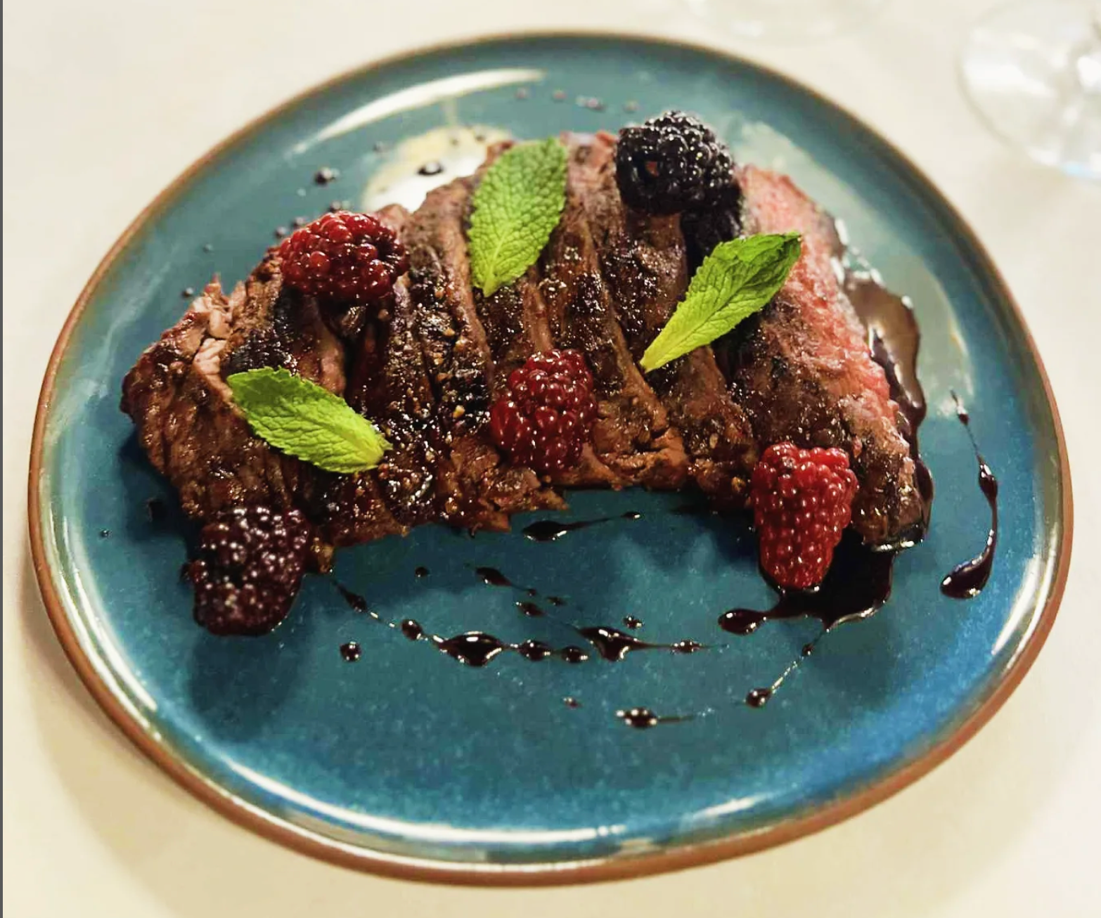 Sweet potato fries topped with shredded meat, cheese, and green onions, served with a dipping sauce.