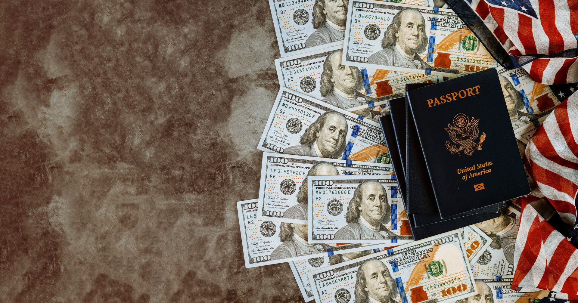 Stack of US passports and $100 bills with an American flag on a textured background.