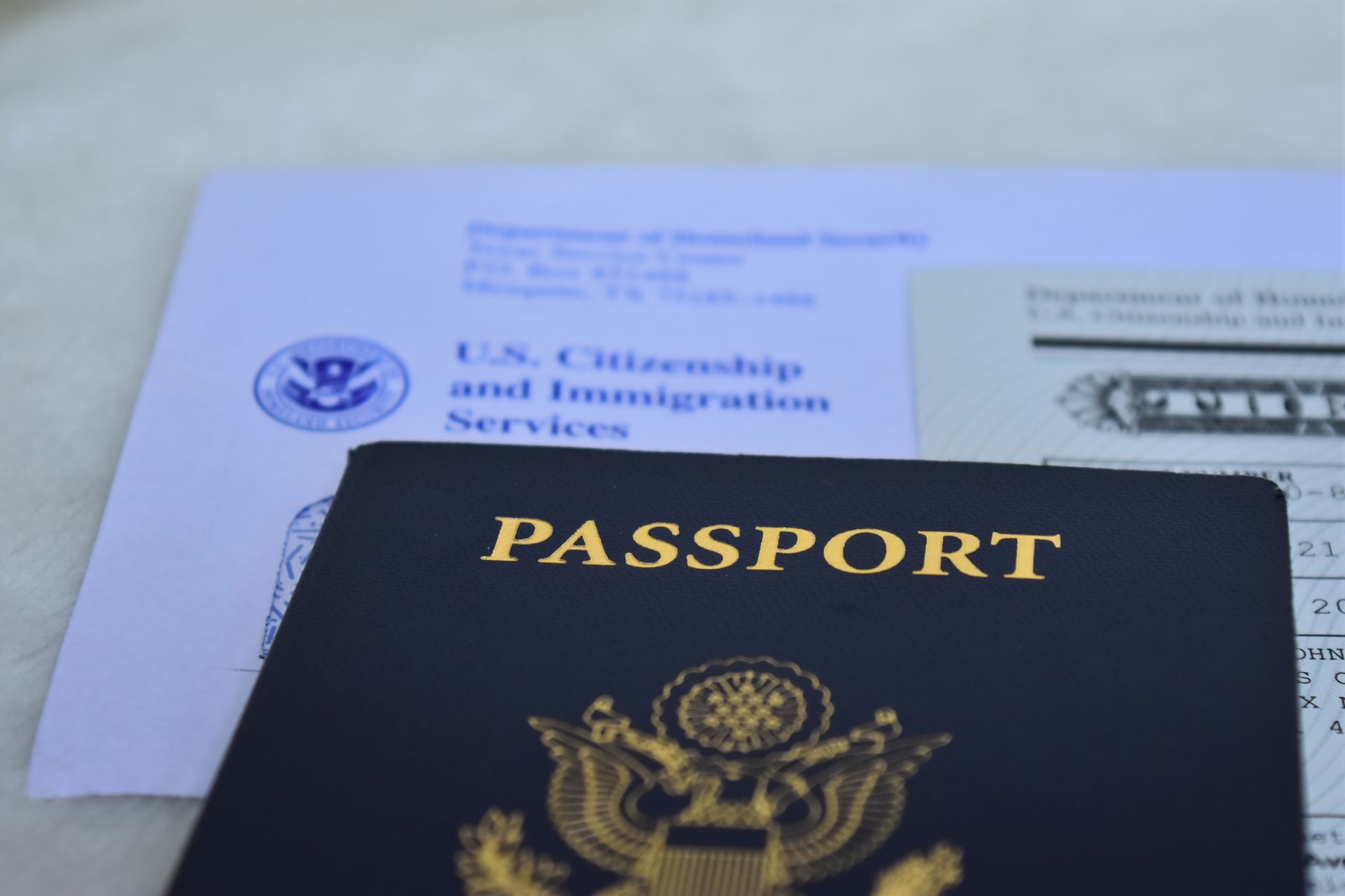 A passport is sitting on top of an envelope from the u.s. citizenship and immigration services