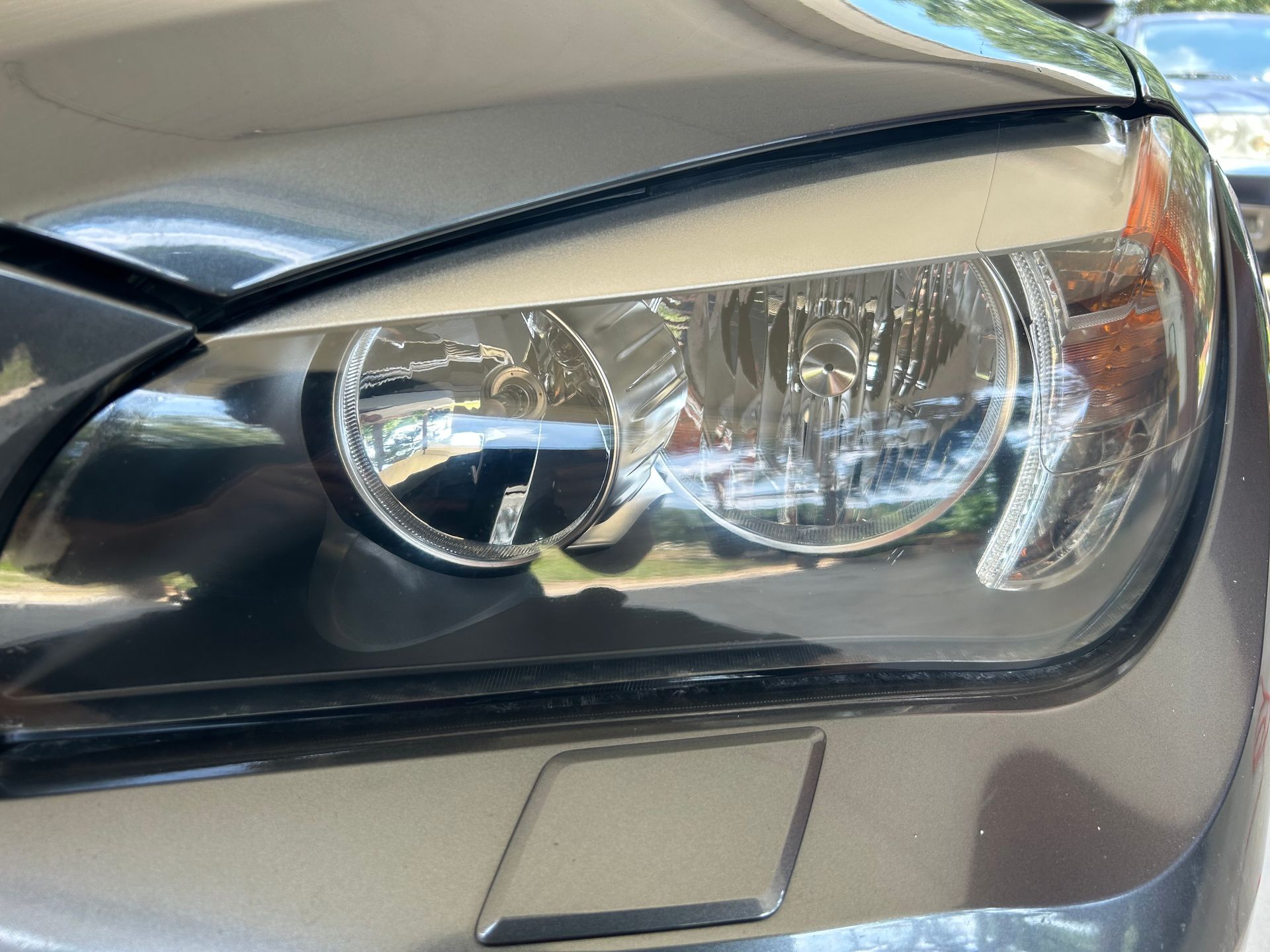 Close-up of a silver car headlight, showing the lens and surrounding body.