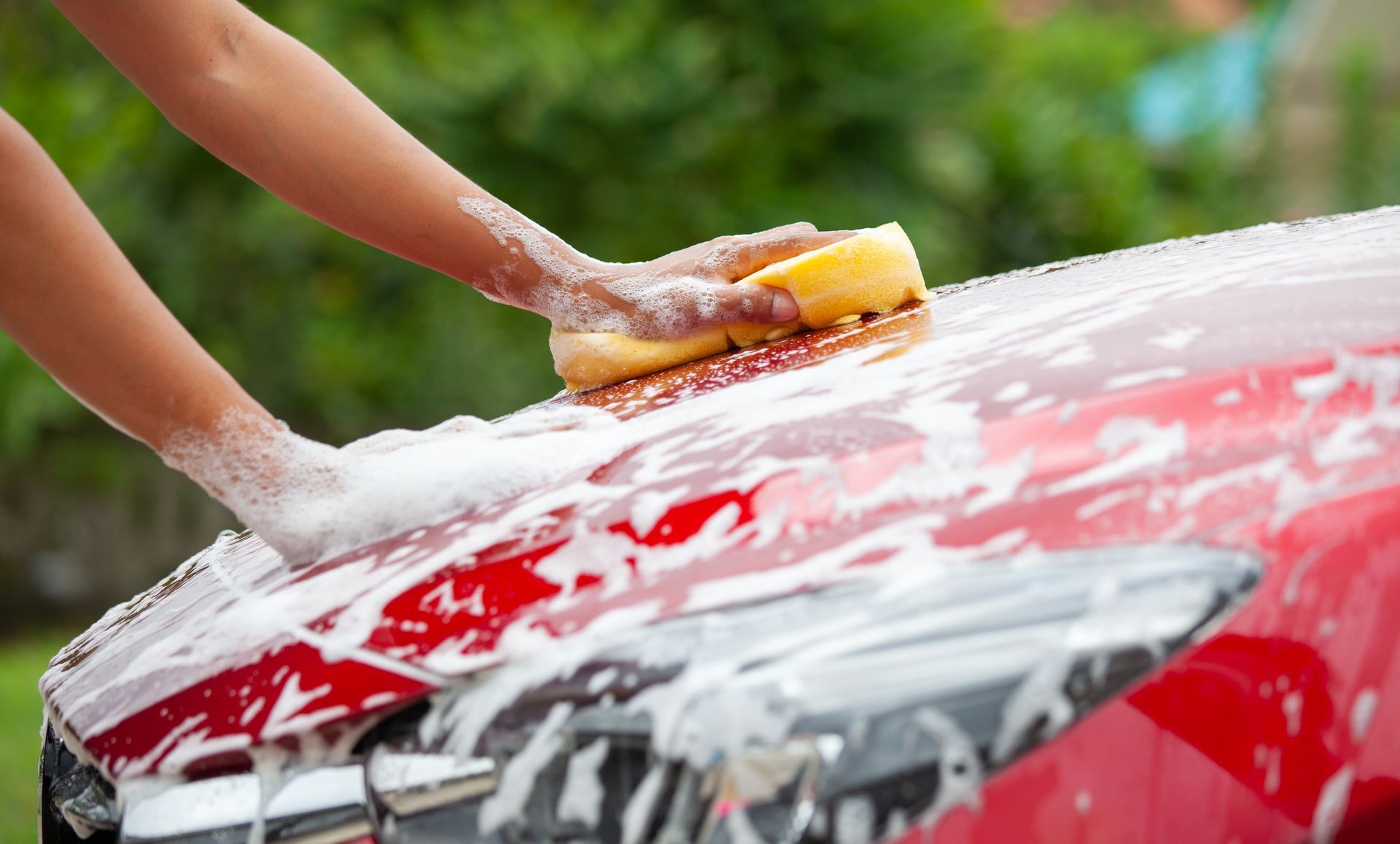 Worker washing red car