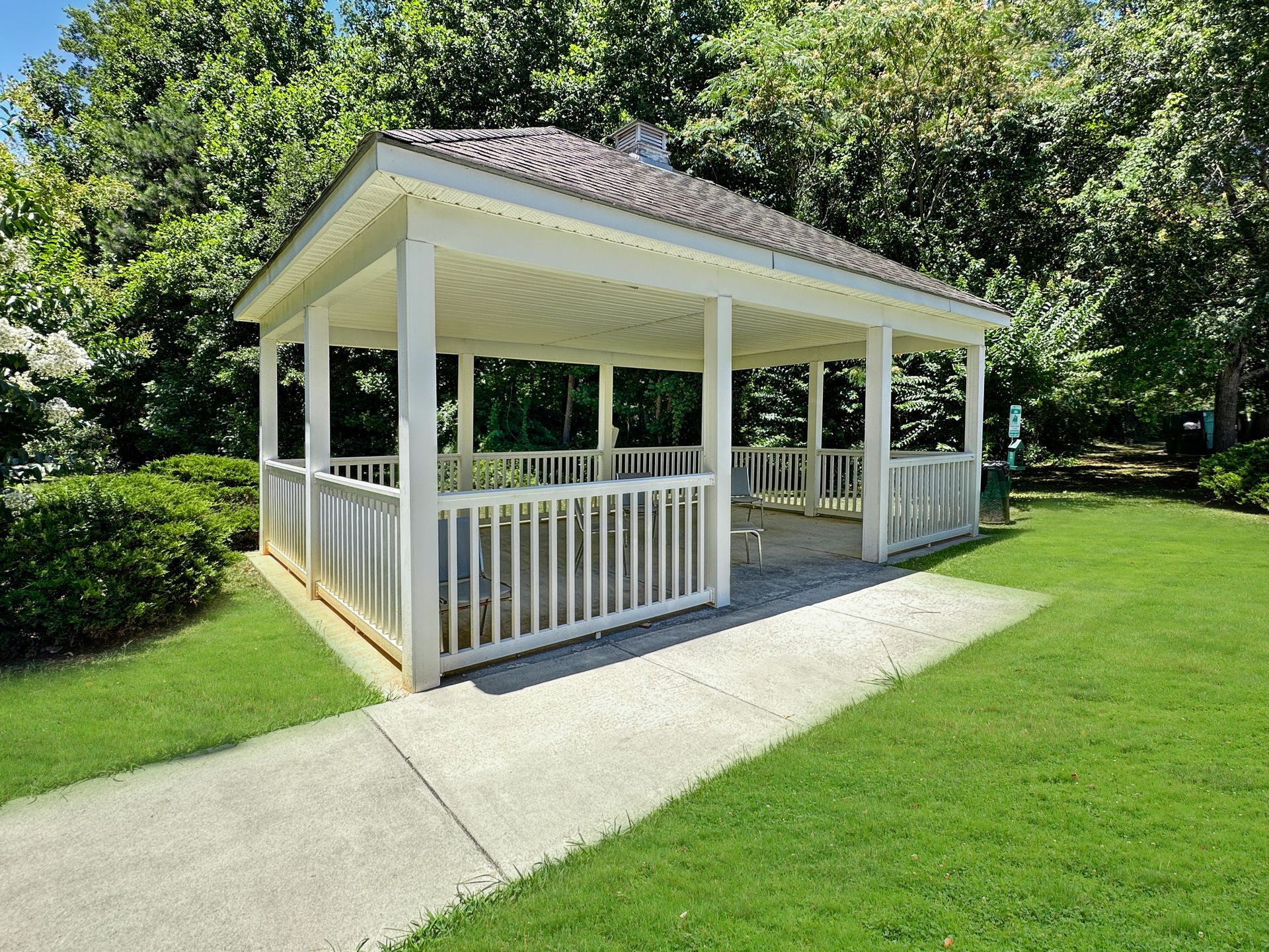 A white gazebo is sitting on top of a lush green lawn.