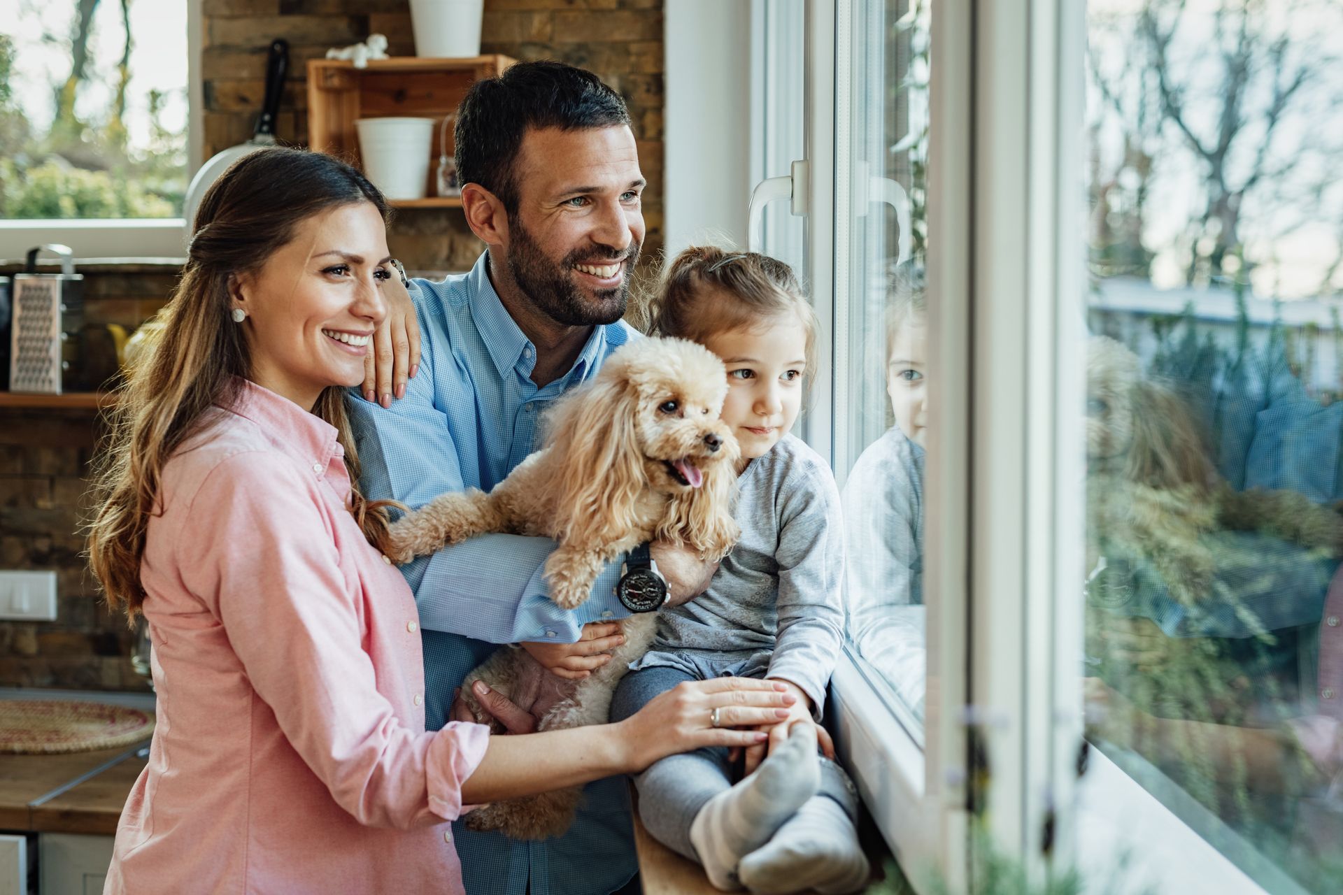 A family with a dog looking out of a window.