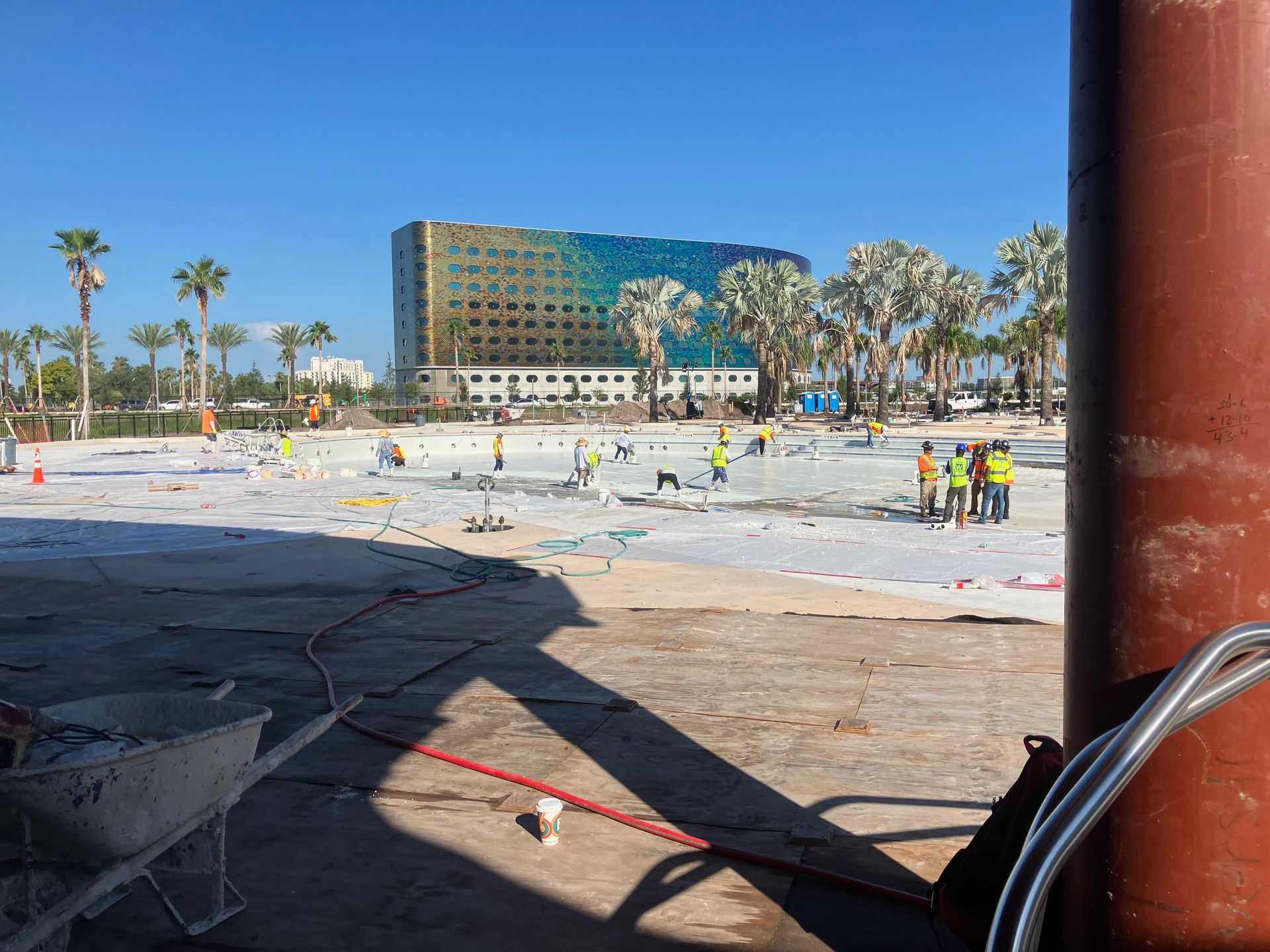 A construction site with a large building in the background.