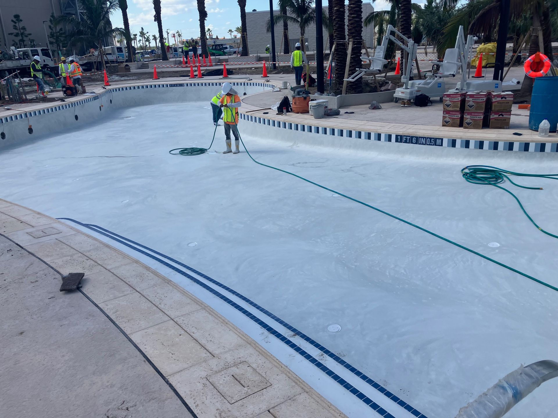 A man is cleaning a swimming pool with a vacuum cleaner.
