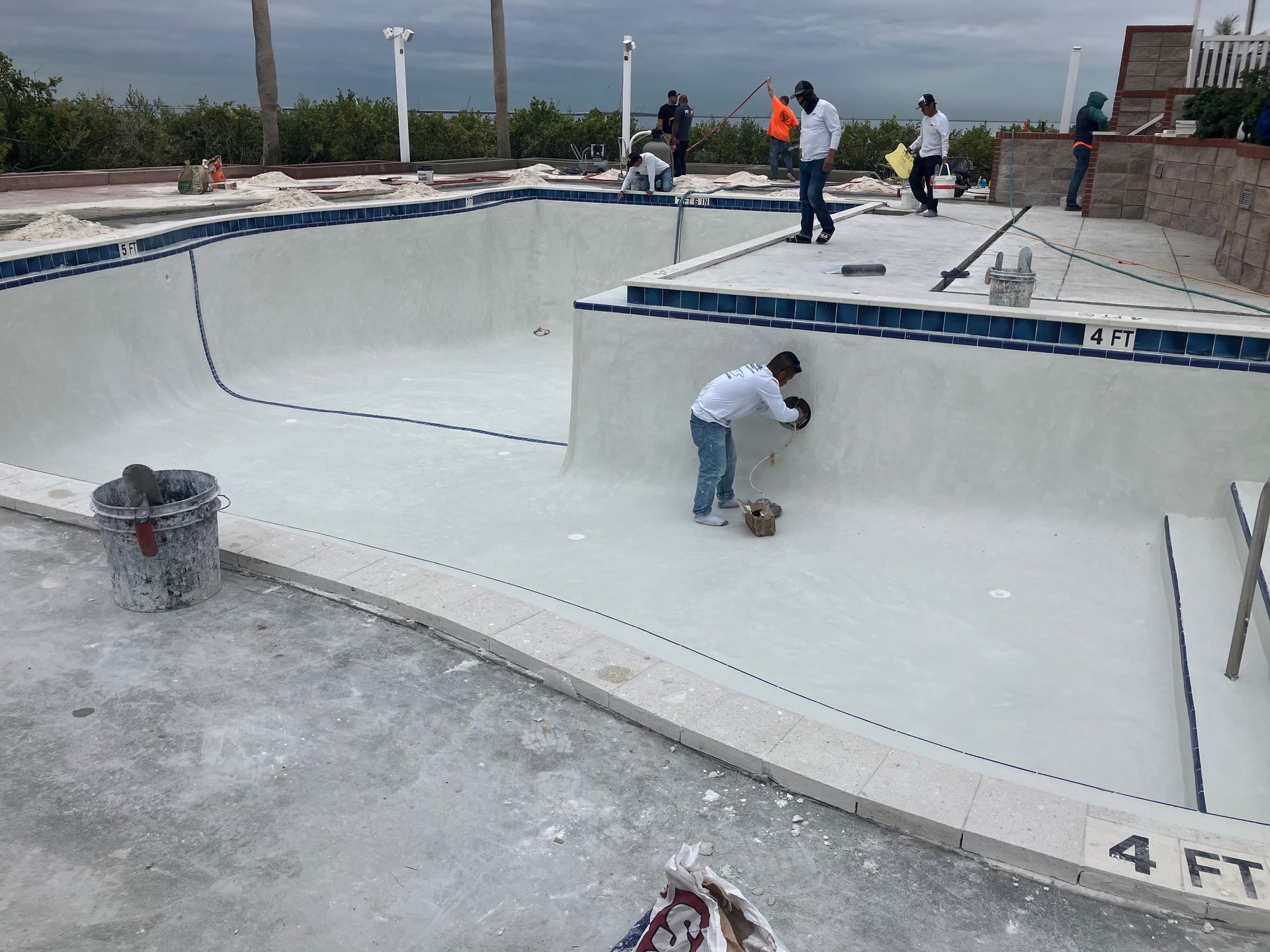 A group of people are working on a swimming pool.