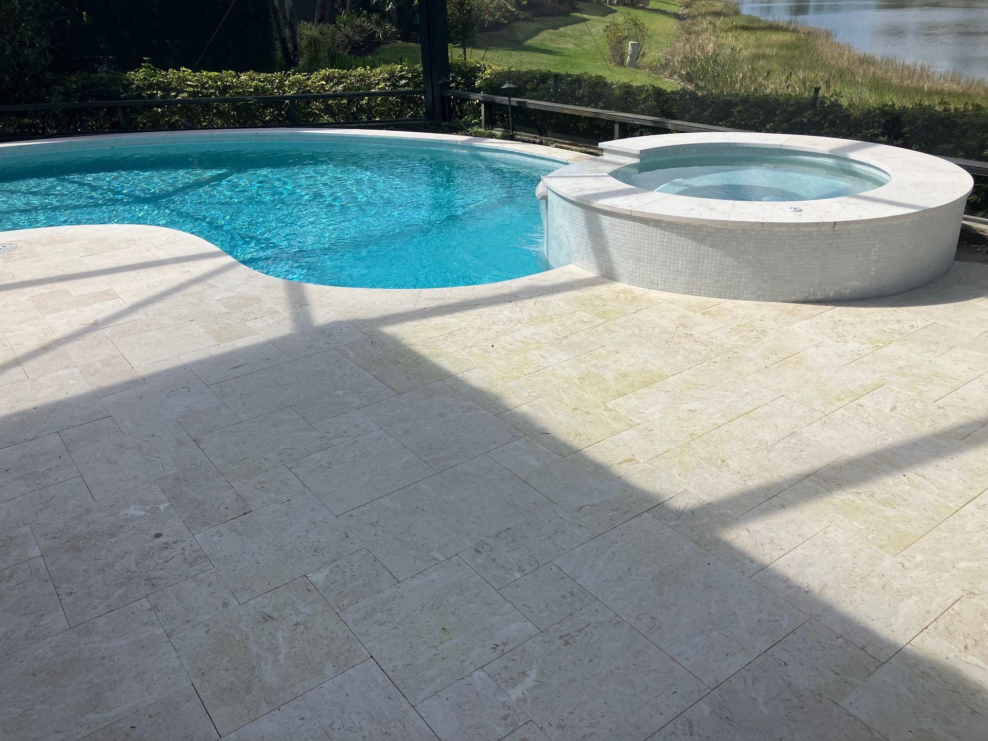 A large swimming pool with a hot tub next to it.