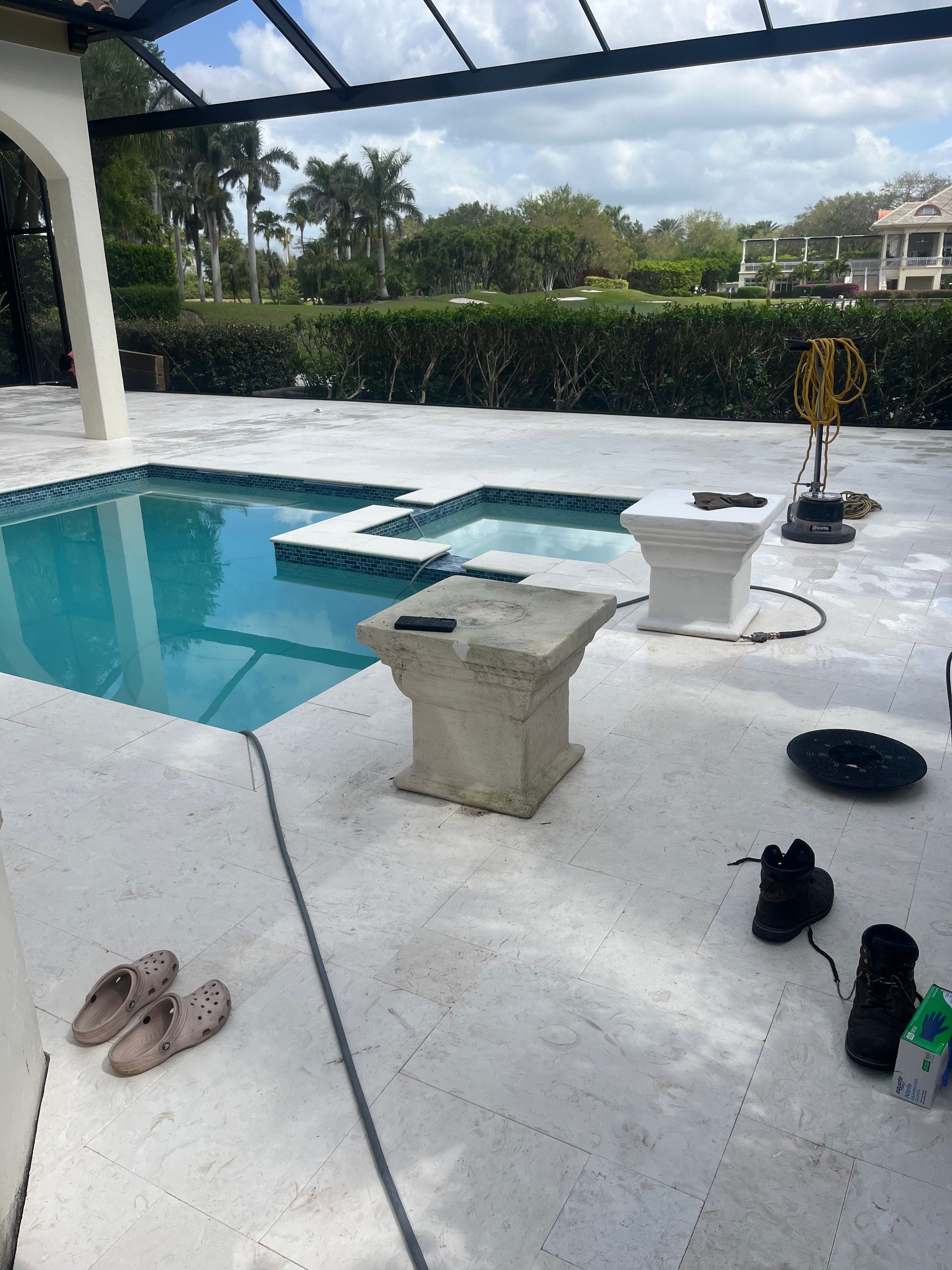 A patio with a swimming pool in the background
