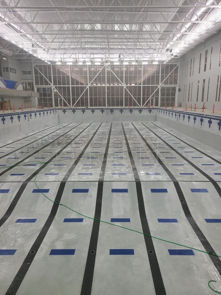 A large indoor swimming pool with blue lines on the floor.