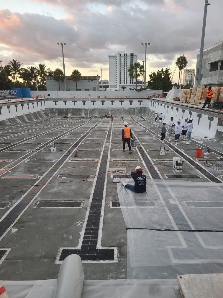 A group of people are working on a large swimming pool.