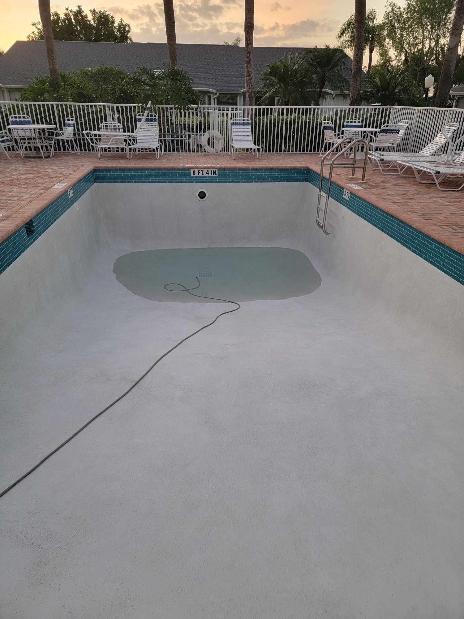 An empty swimming pool with a hose coming out of it.
