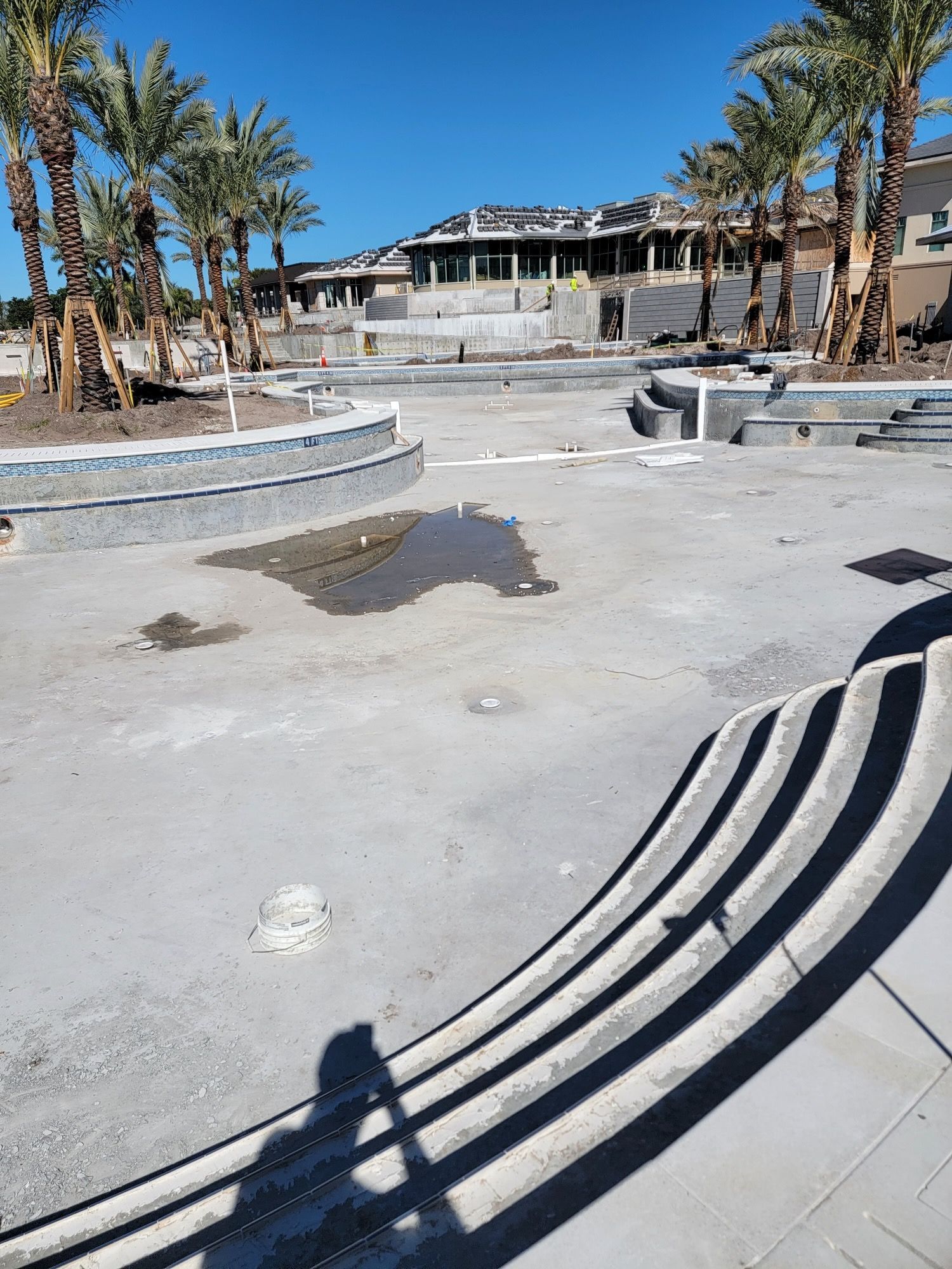 A shadow of a person is cast on a concrete surface.