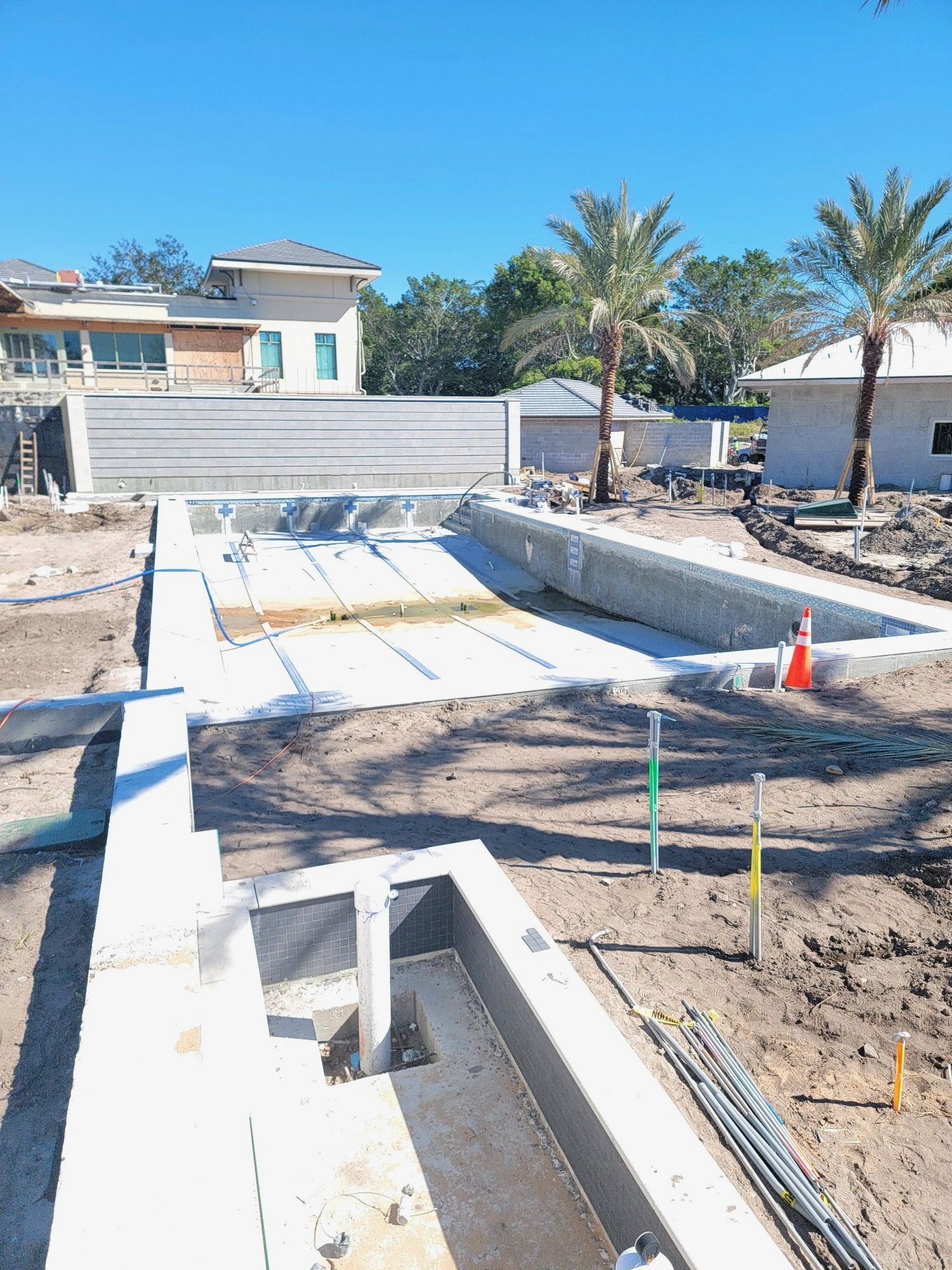 A swimming pool is being built in the middle of a dirt field