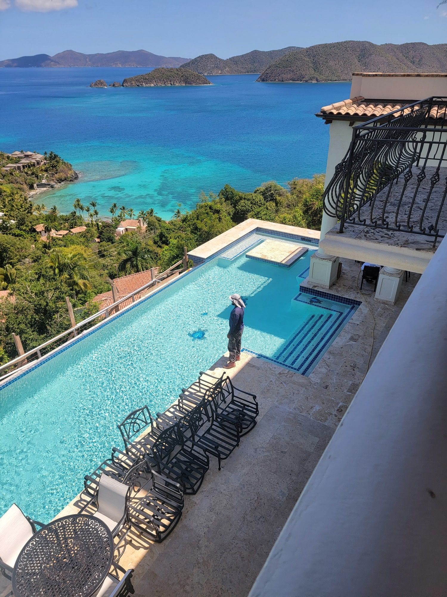 An aerial view of a large swimming pool overlooking the ocean.