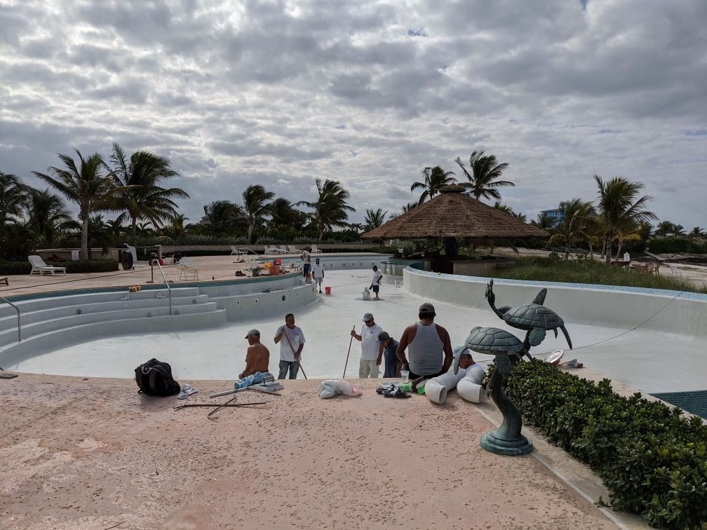 A group of people are working on a swimming pool.