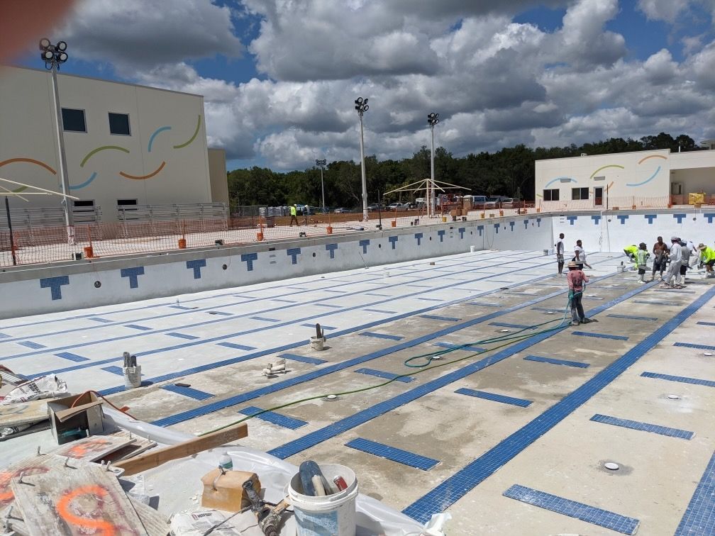 A group of people are working on a large swimming pool.