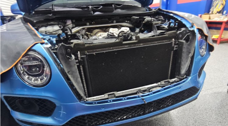 Blue car with its hood open, revealing the engine bay - Bimmerfix