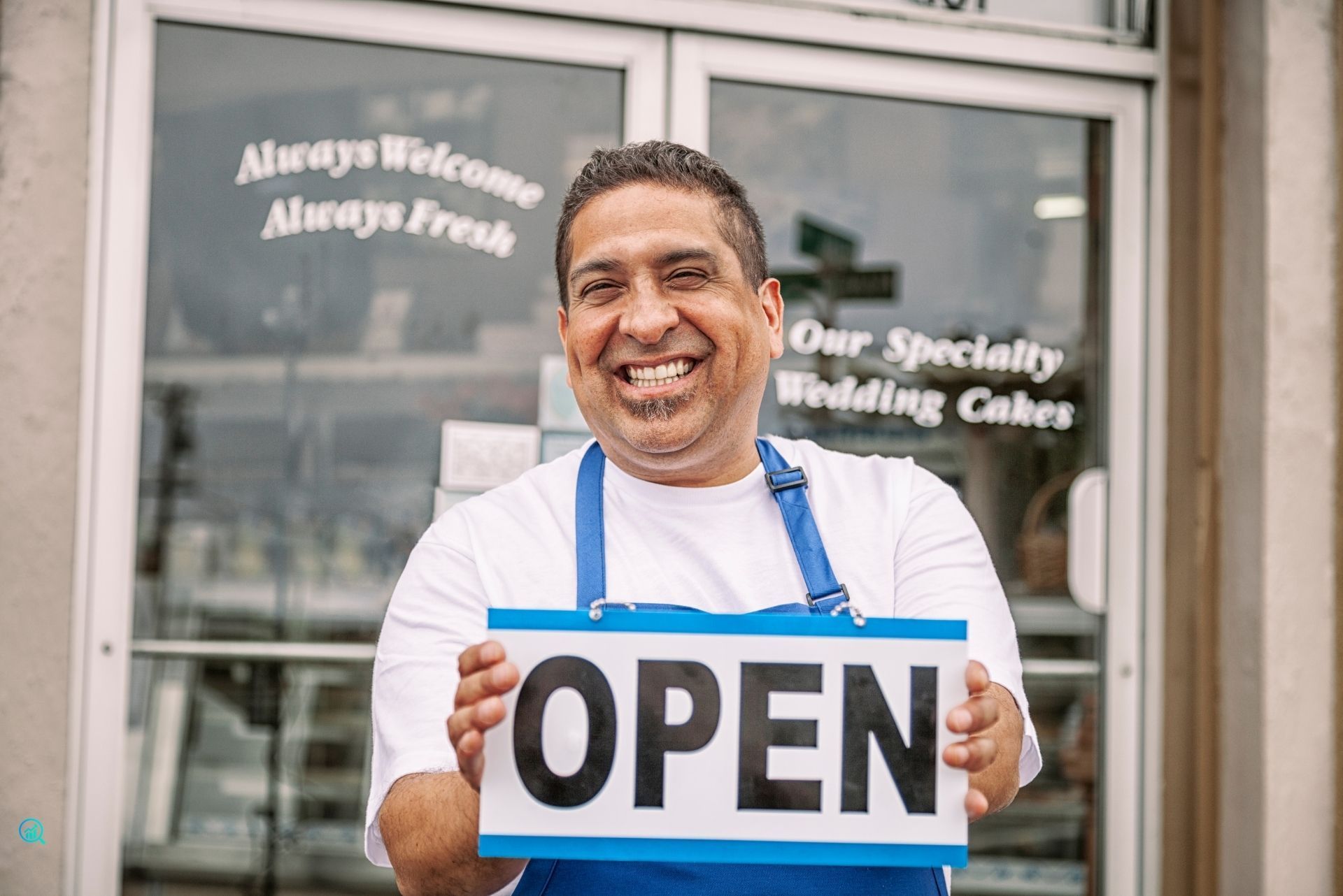 Smiling small business owner holding an open sign, representing local business marketing services by Growth Reach Digital.