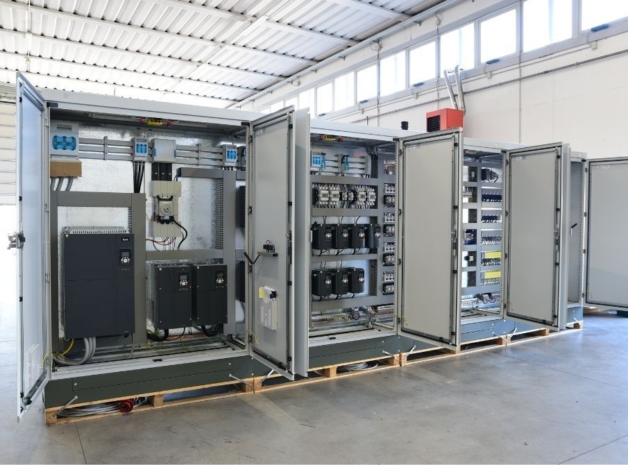Electrical control panel with various components, including breakers, motor drives, and a power supply.