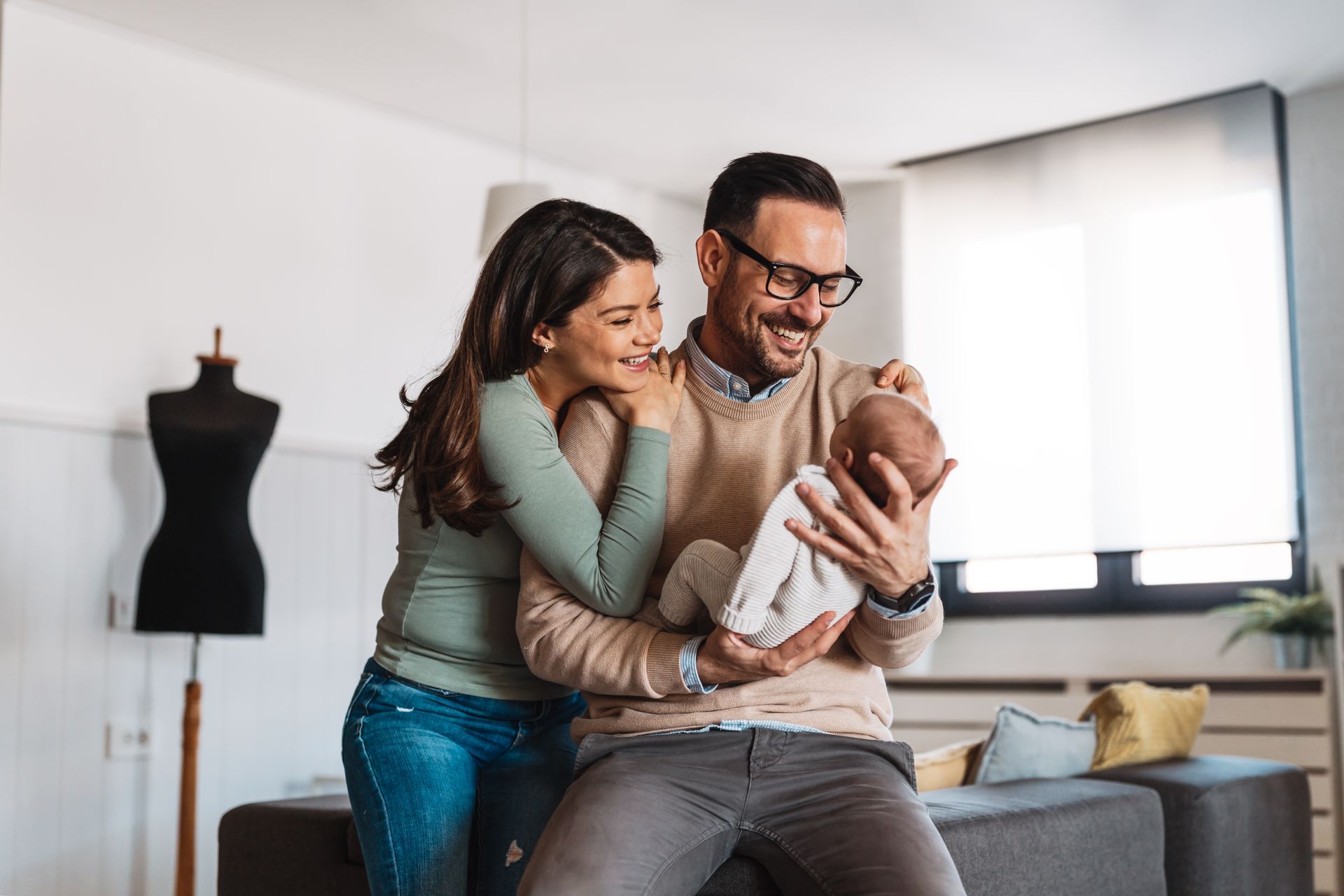 A man and a woman are holding a baby in their arms.