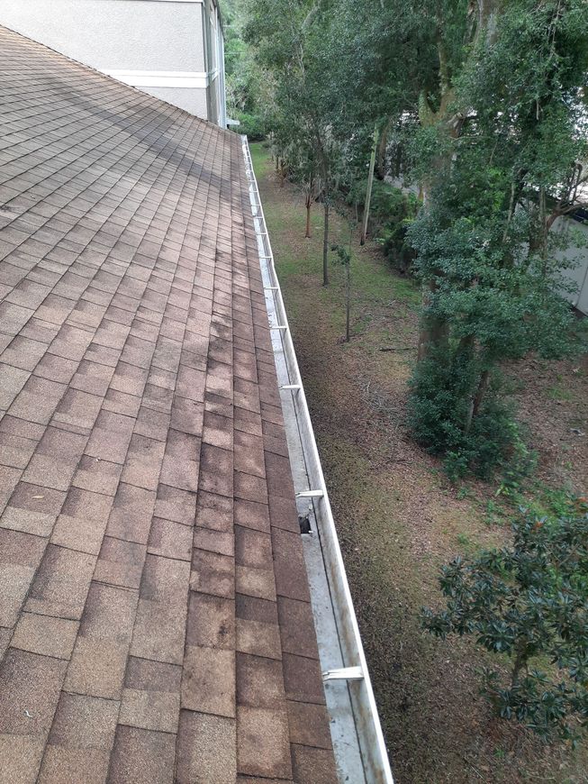 There is a gutter on the roof of a house.
