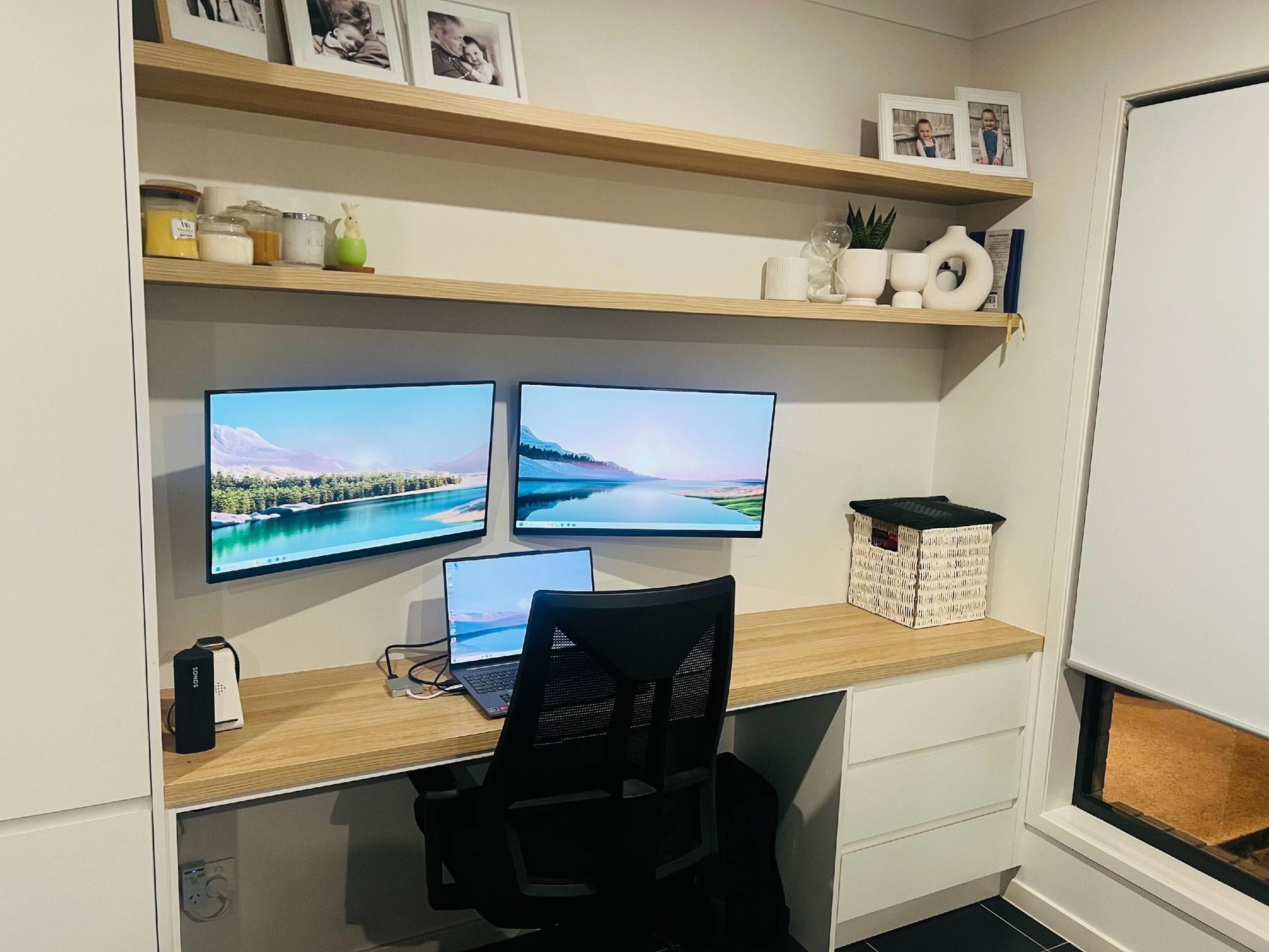 A desk with two monitors and a laptop on it.