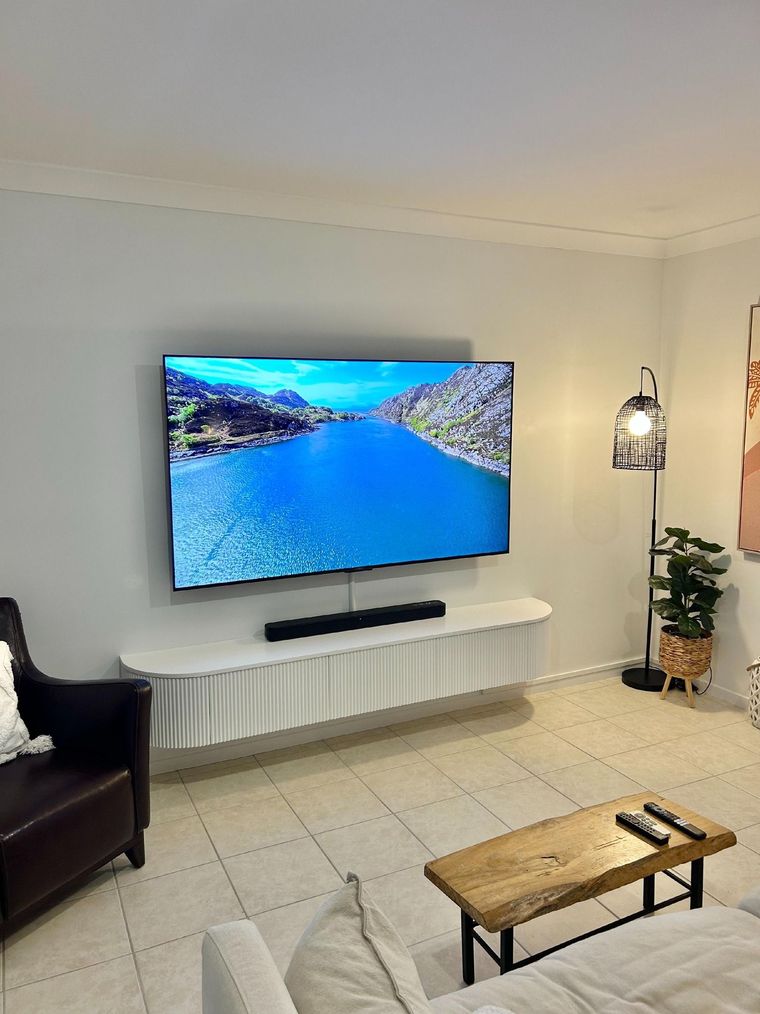 A living room with a flat screen tv hanging on the wall.