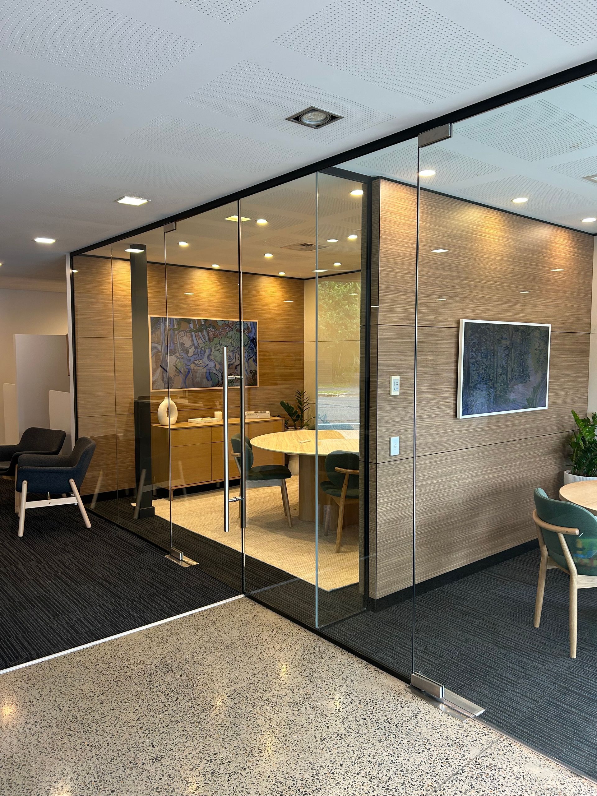 A conference room with a long table and chairs and a projector screen.