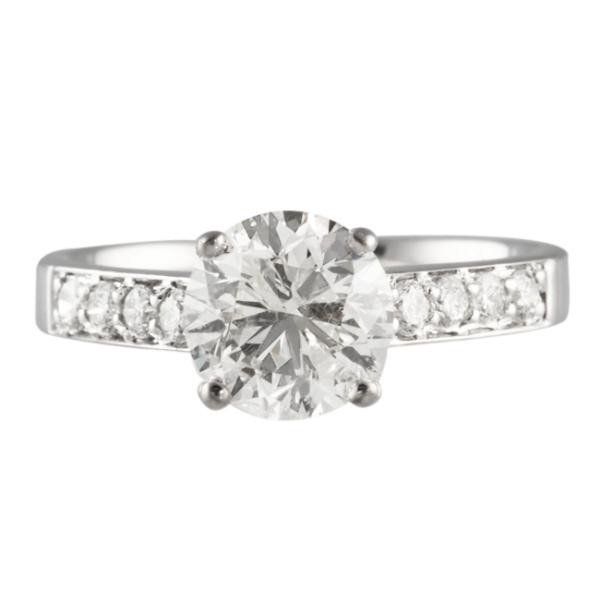 Round-cut diamond engagement ring with channel-set side diamonds on a white gold band.
