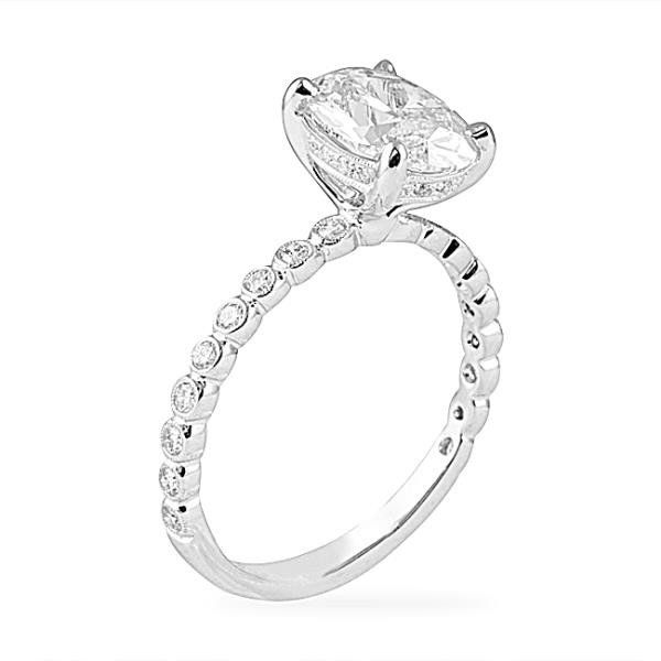 Oval diamond engagement ring with bezel-set diamond band in white gold
