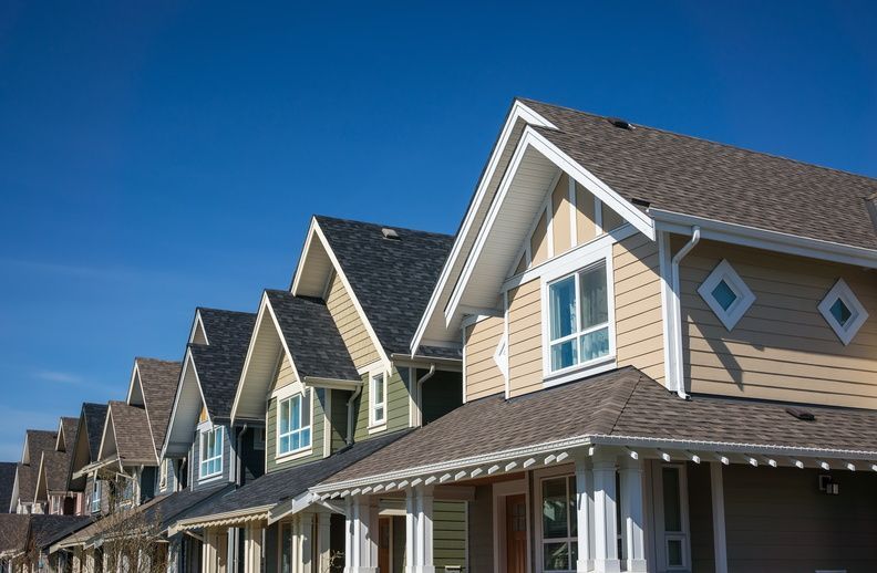 A row of houses with a blue sky in the background