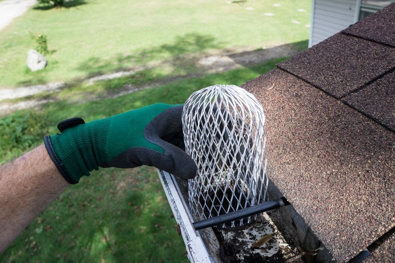 A person is cleaning a gutter with a net.