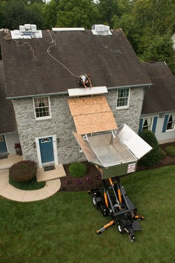 A man is working on the roof of a house.